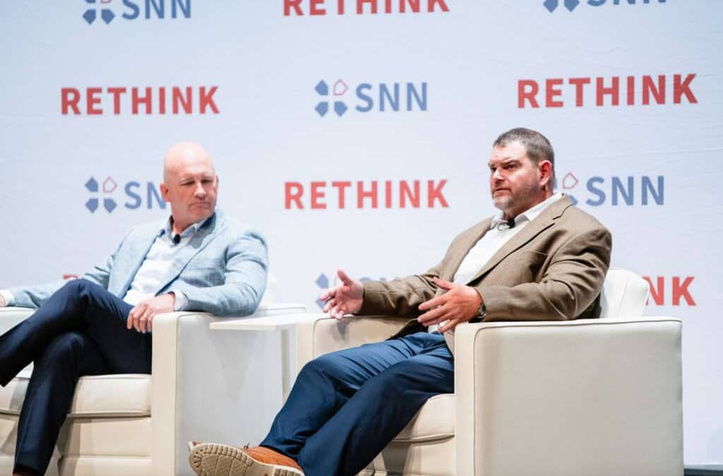 Two men on a panel talking